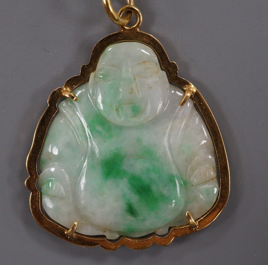 A yellow metal mounted jade pendant, carved with a Buddha, 32mm.